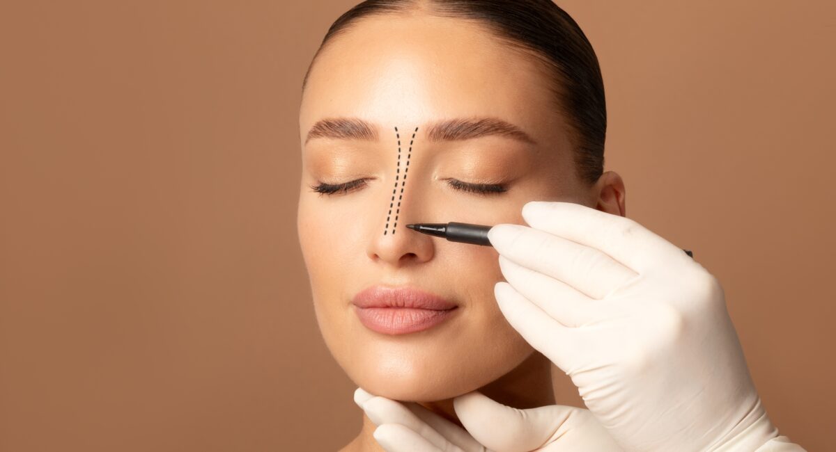 Rhinoplasty,Concept.,Doctor's,Gloved,Hand,Making,Marks,On,Female,Face,